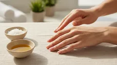 Handpflege mit natürlichem Öl und Salz, Nahaufnahme auf Händen und Schalen auf Tisch.
